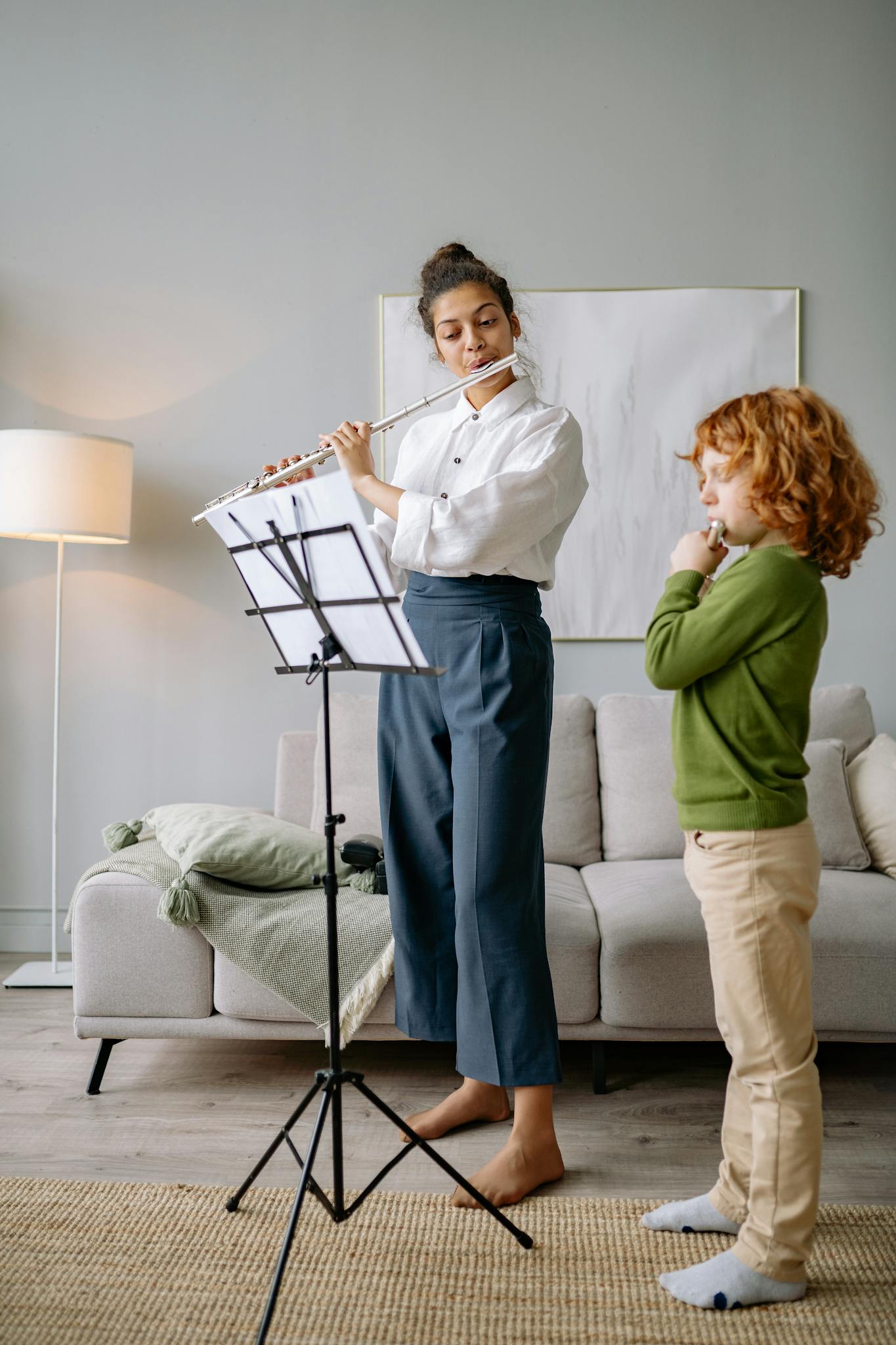 A child receiving flute lessons from a teacher in a cozy home setting.