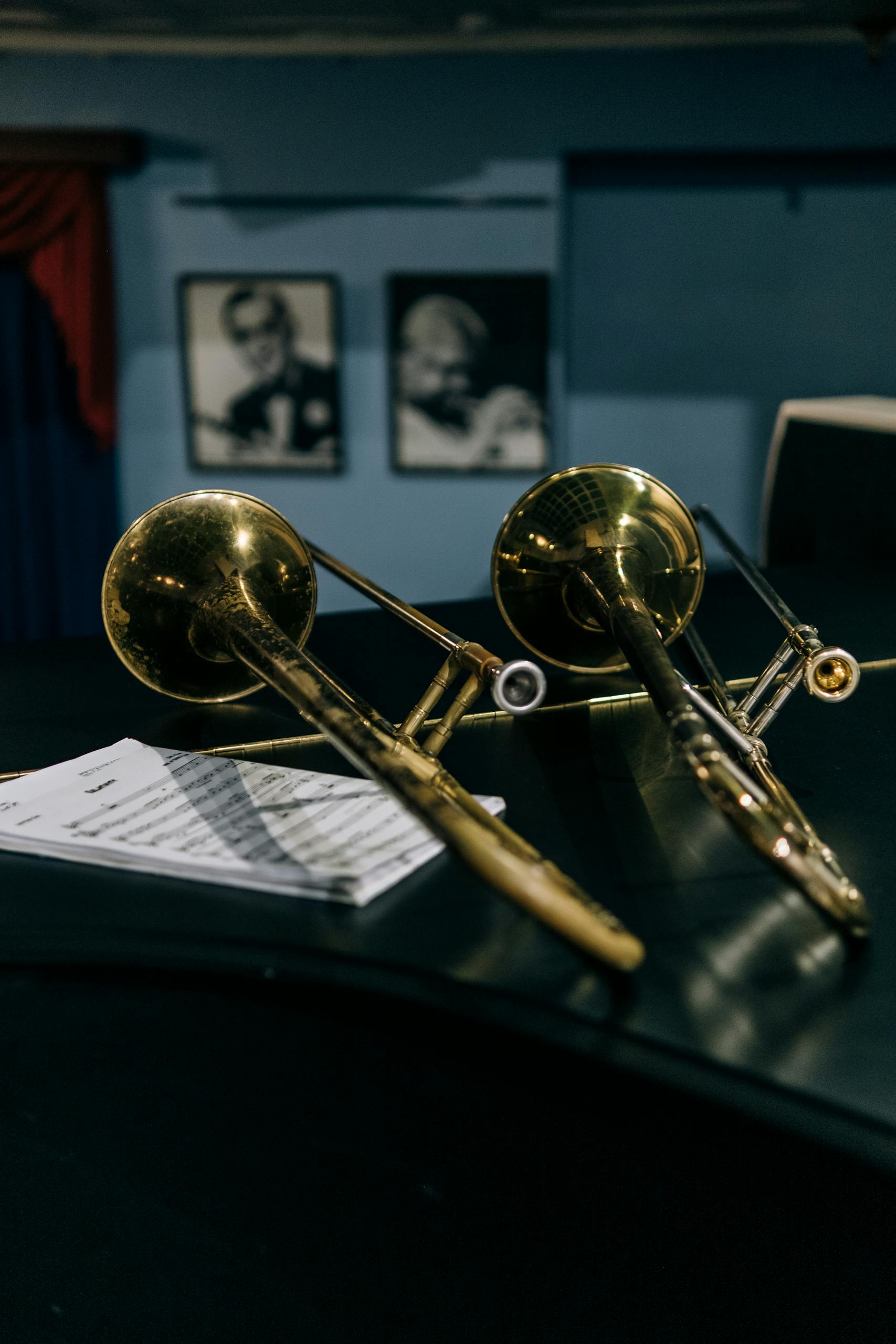 Close-up of two trombones and sheet music in a jazz setting.